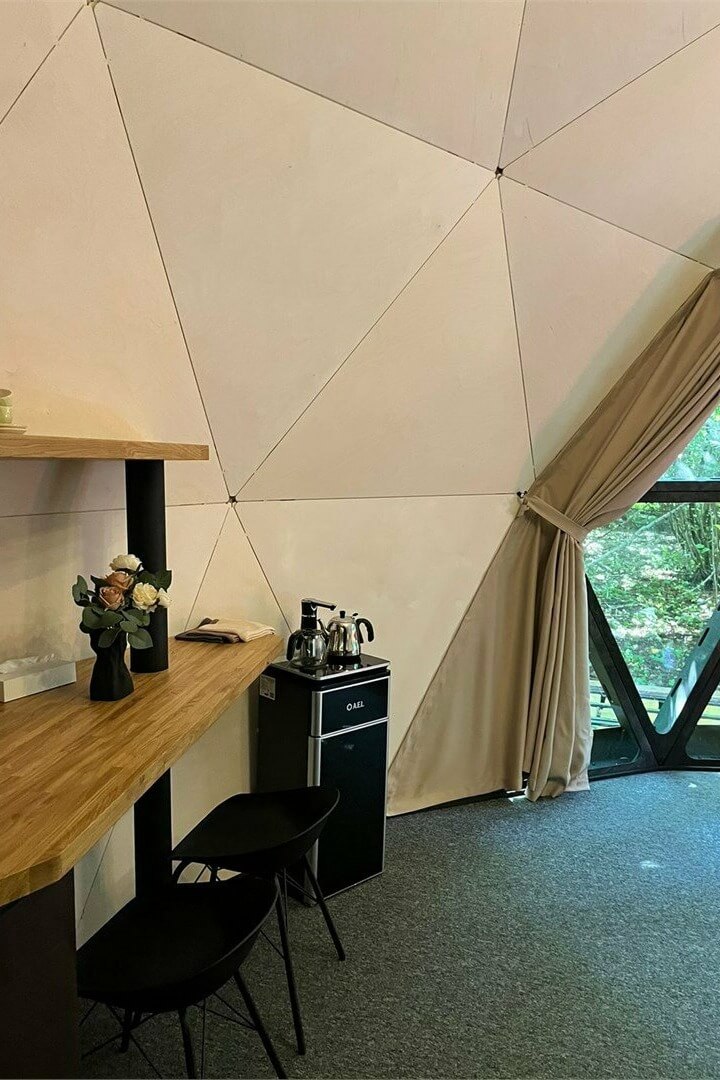 Интерьер купольной палатки с письменным столом и камином.