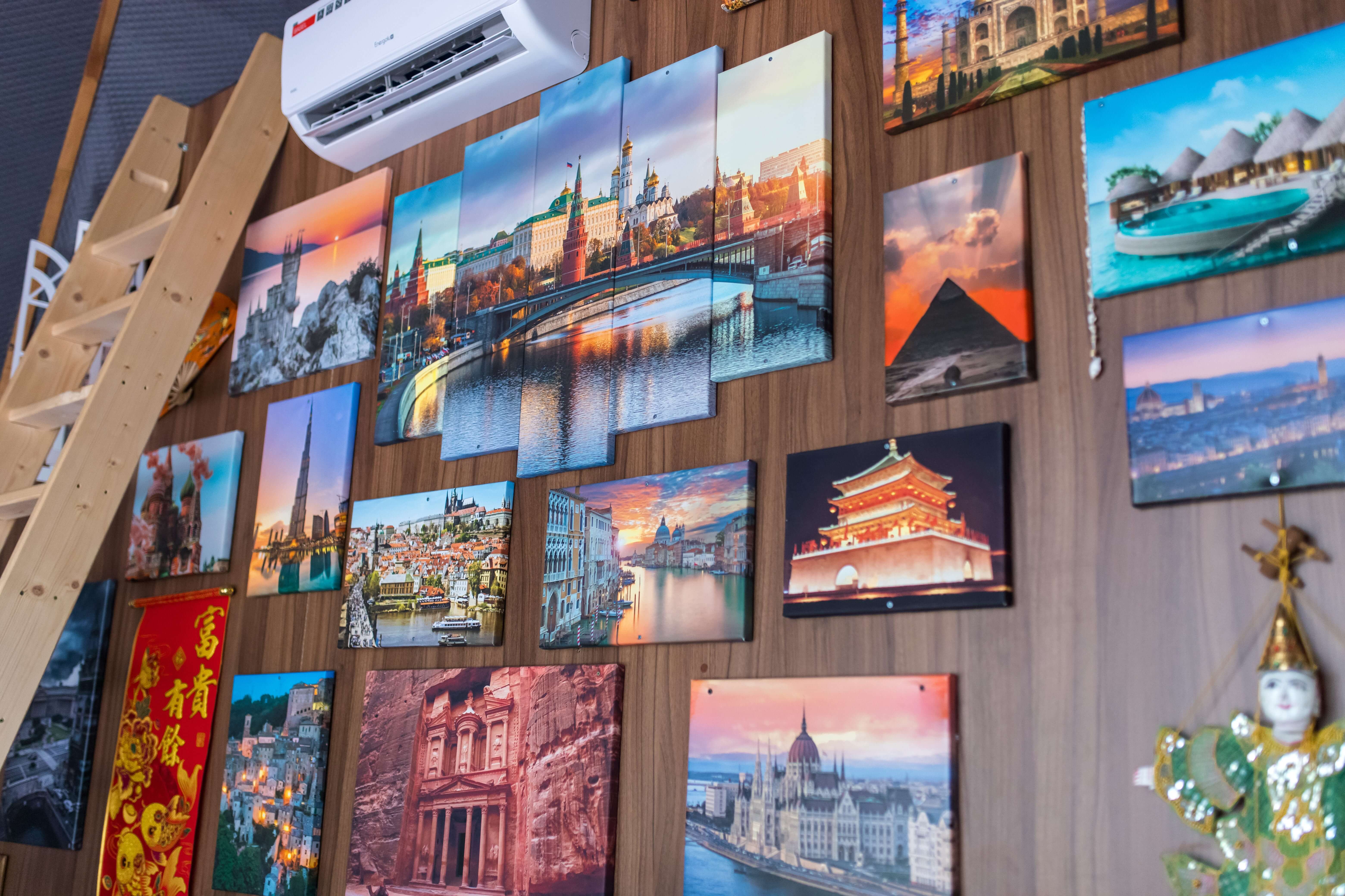 Стена с фотографиями достопримечательностей мира в интерьере.