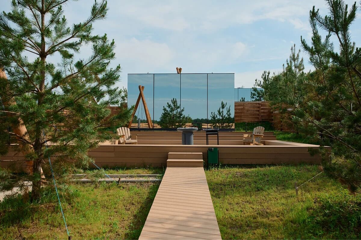Каркасный дом с панорамным остеклением среди соснового леса.