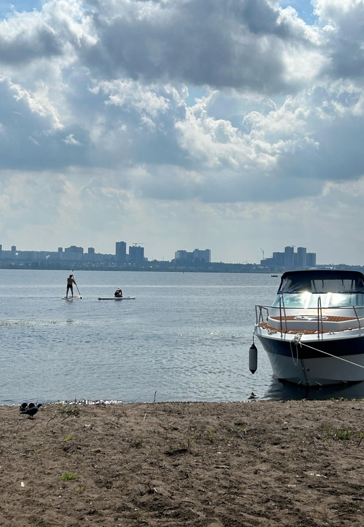 # Alt-текст:

Причал с моторной лодкой и вид на городские небоскребы.