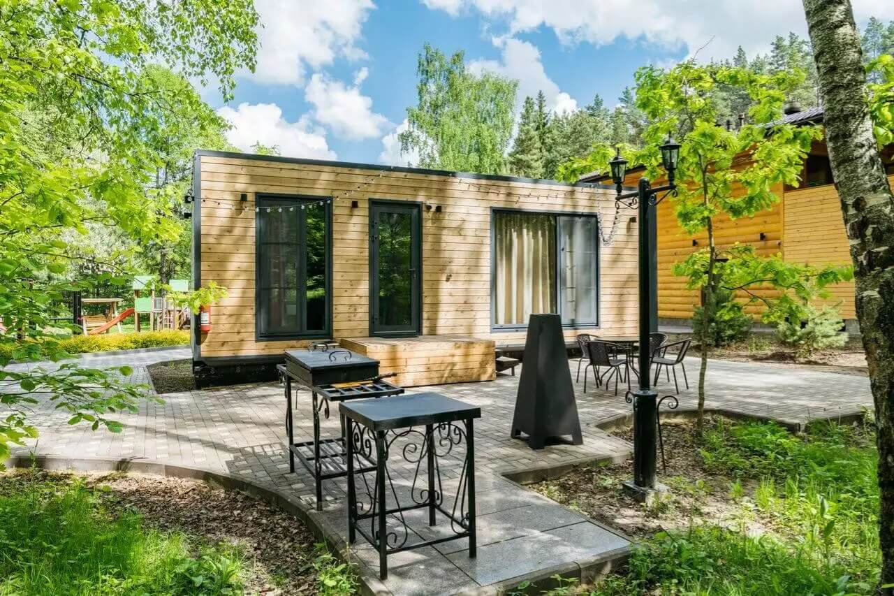 Каркасный дом с террасой среди хвойного леса.