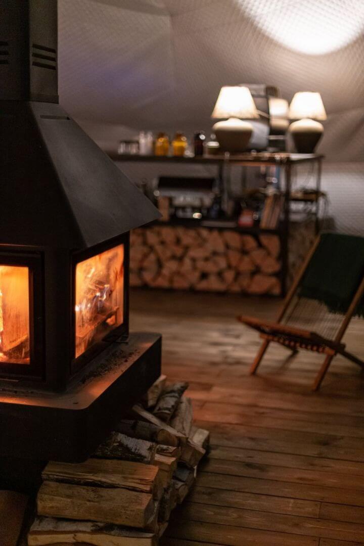 Интерьер номера с камином и лампами под скатной крышей.