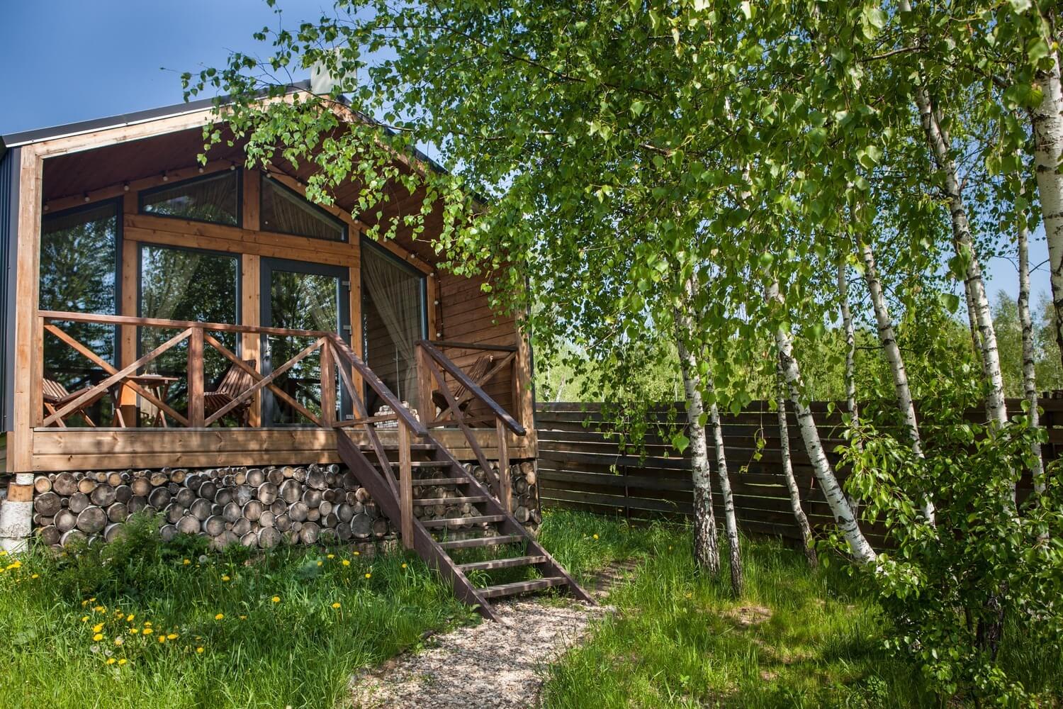 Каркасный дом на каменном фундаменте среди берёз.