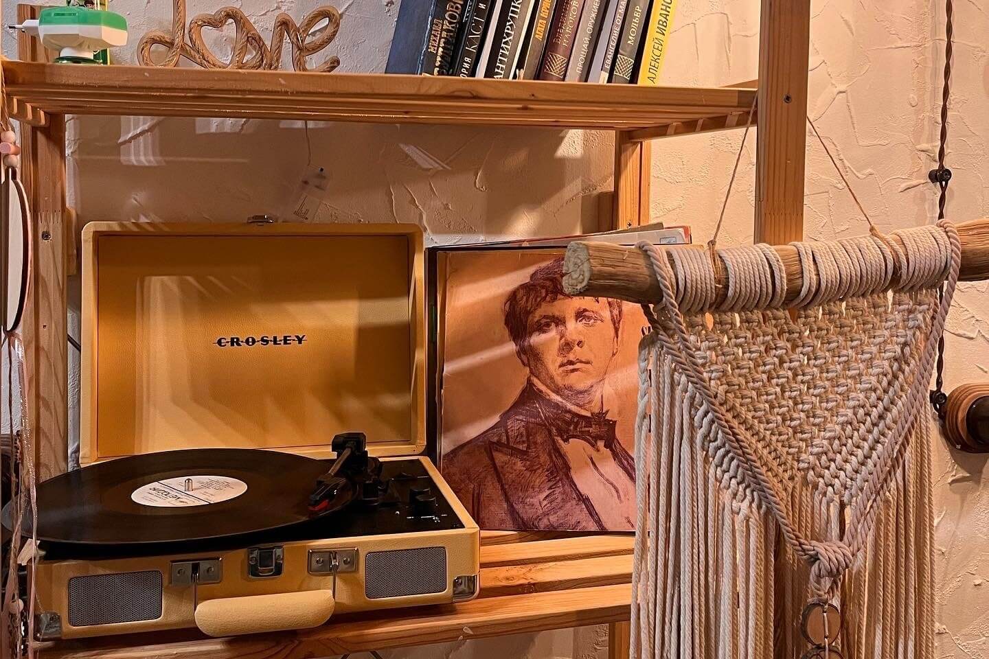 # Alt-текст:

Виниловый проигрыватель Crosley на полке в номере.