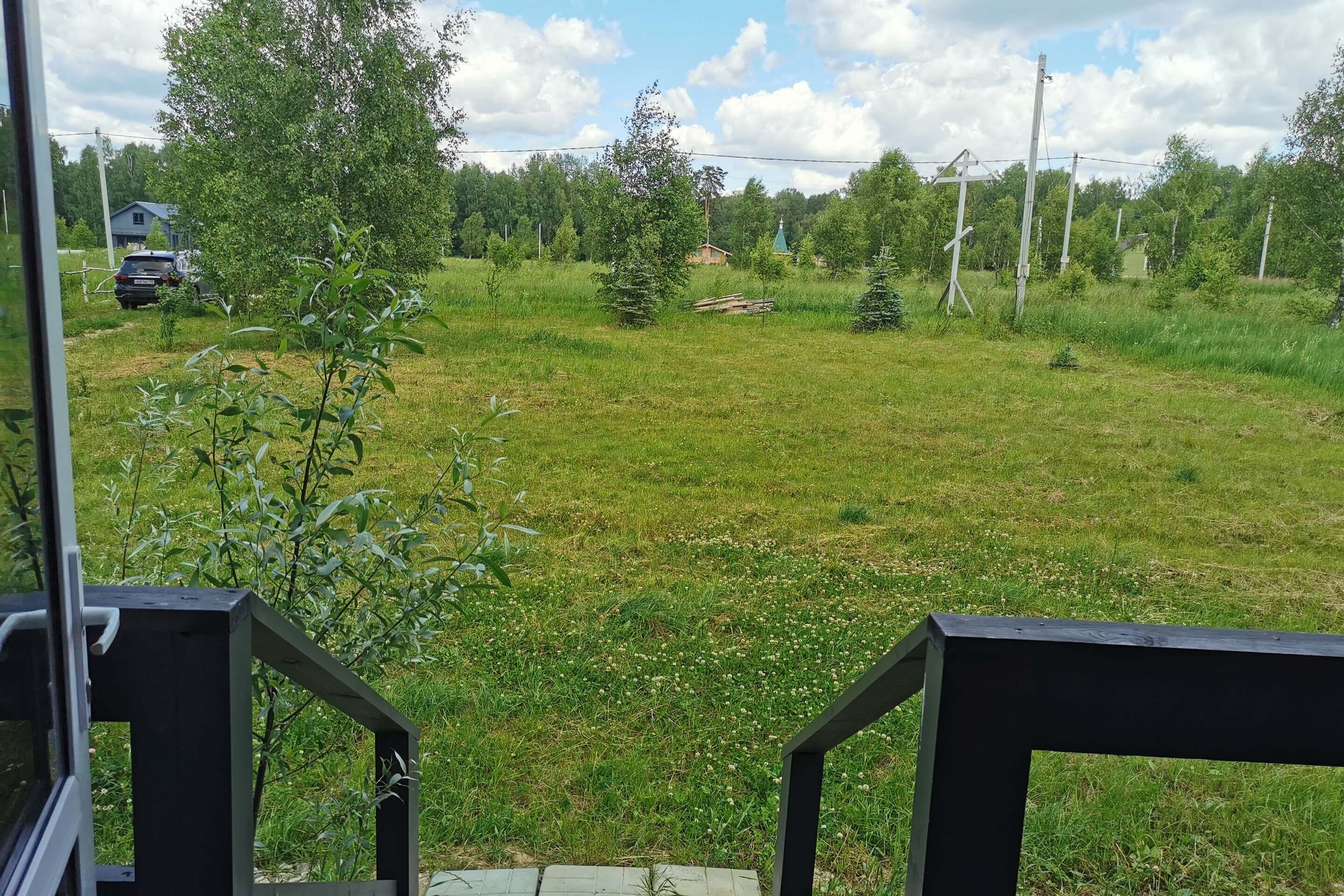 Вид с веранды на лесную поляну с сосна­ми.